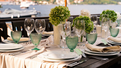 Close-up of a decorated table and a white plate and cutlery. Large table setting for a wedding or birthday.