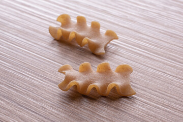 whole wheat durum wheat pasta on wooden background