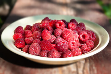 Raspberry berries. Close-up of raspberries in a bowl. Selective focus. Small depth of field. Blurry background with bokeh effect