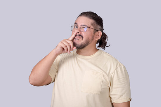 A classless man in his 30s picking his nose for a booger in an unmannerly fashion.