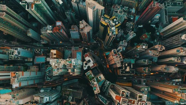 Drone shot, traveling backward, of a huge city with hundreds of skyscrapers during the day. It's an urban jungles like a maze and the streets busy with cars