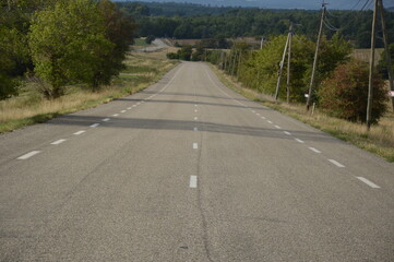 Long asphalt road in the countryside, France