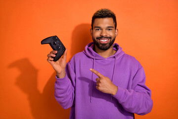 Portrait of satisfied funny cheerful guy use advises buy playstation point hand isolated on orange color background