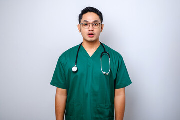 Impressed and surprised asian male nurse or doctor in scrubs drop jaw and stare at camera speechless, looking amazed