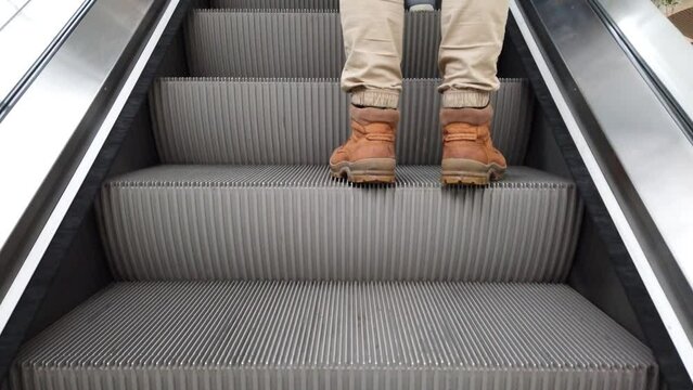 Movement of the escalator. The man walks up the escalator.