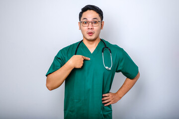 Surprised and ambushed asian male physician, nurse in scrubs pointing at herself, beaing named or...