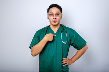 Surprised and ambushed asian male physician, nurse in scrubs pointing at herself, beaing named or chosen