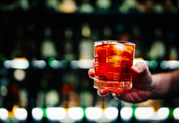 man hand holding a glass of cocktail in a bar