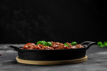 Meatballs with tomato sauce in frying pan on black background, banner, menu, recipe place for text