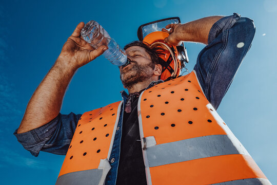 Arbeiter in Sicherheitskleidung schwitzt in der Sonne