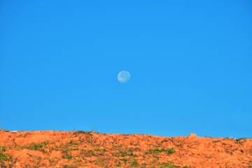 Full moon in beautiful blue cloudy sky in early morning.