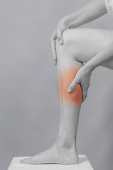 Long female bare leg bent at the knee. A woman's hand touches her leg. Pain in the leg.