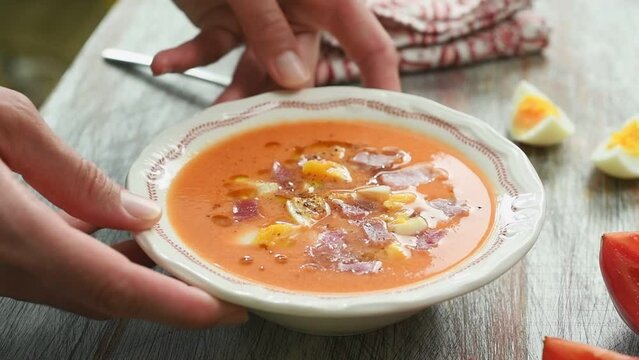 The chef serves the cold tomato Spanish soup.
