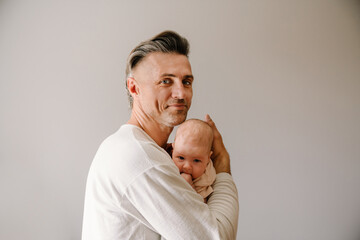 Mid white father smiling while spending time with her baby - obrazy, fototapety, plakaty