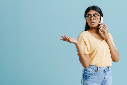 Young Beautiful Serious Indian Woman In Glasses Talking Phone