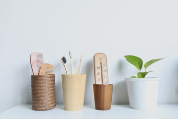 Fototapeta na wymiar Eco friendly bamboo toothbrush and hair brush and thermometer and plant pot