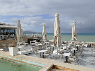 Fototapeta premium Tables and umbrellas on the Heraklion waterfront, Heraklion, Crete island, Greece