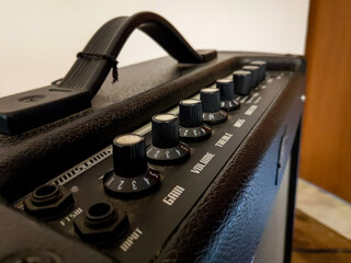 A top of a black guitar amplifier. treble, bass knobs. India