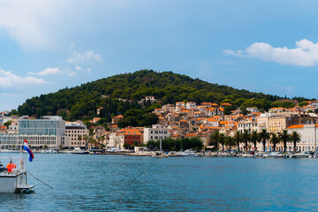 beautiful town with a hill in the background and a promenade with palm trees and boats in Split, Croatia