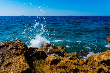 waves crashing on rocks in Primosten, Croatia