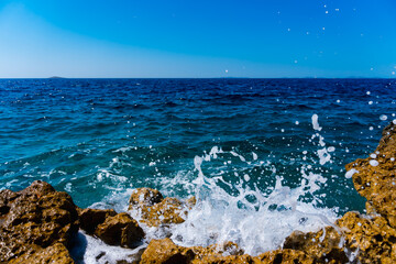 waves crashing on rocks in Primosten, Croatia