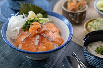 Salmon sashimi on rice and vegetable side dishes 