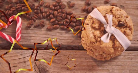 Animation of golden stars over christmas cookies, coffee beans and candy canes - Powered by Adobe