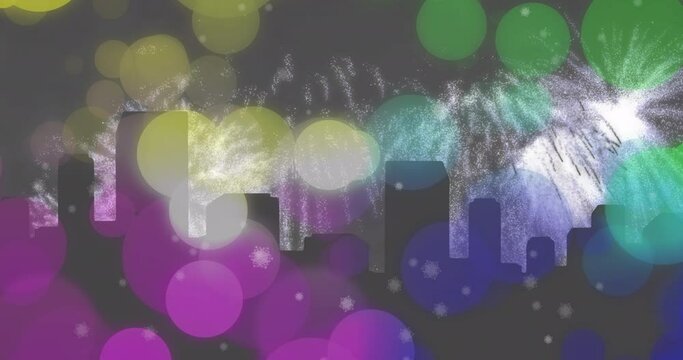 Animation of colourful spots over white new year fireworks exploding and silhouetted cityscape