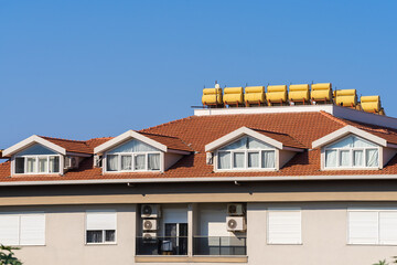 The roof of an apartment building with installed solar water heaters.