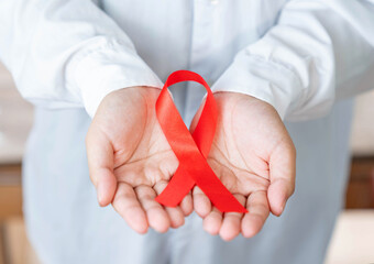 The man in white shirt hold red ribbon concept of against aids