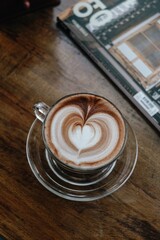 latte art coffee cup on wooden top table background.