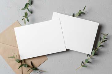 Iinvitation card mockup with envelope and eucalyptus twigs, front and back sides