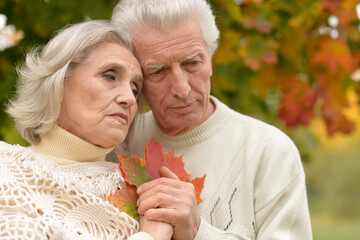 Portrait of a sad seniors in autumn park