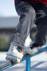 Roller blader grinding on handrail. In line skater grind on rails in skatepark outdoor