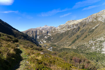 Mountain panorama in the Swiss Alps at region of mountain pass Furkapass with serpentine road of Grimselpass in the background. Photo taken September 12th, 2022, Goms, Switzerland.