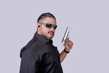 An experienced bodyguard or security escort with an earpiece and holding a handgun ready to defend...