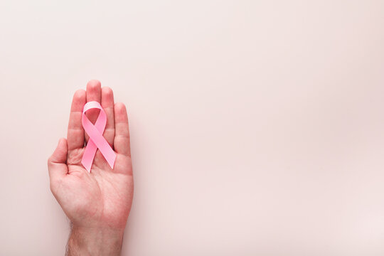 Pink Breast Cancer Awareness Ribbon. Hands holding pink ribbon on backgrounds. Breast cancer awareness and October Pink day, world cancer day. Top view. Mock up.