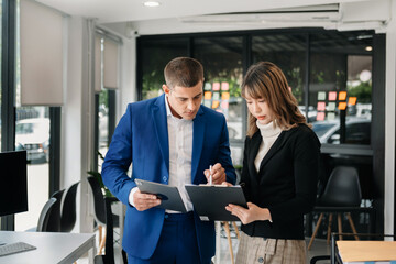 Business colleague business presents and explains and using laptop and tablet. Teamwork, financial marketing team, while sitting in modern office room..