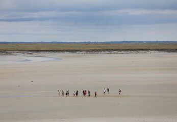 travelers walking on the sea at low tide on an adventurous excursion