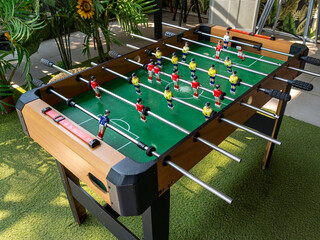 An entire foosball table with red and yellow dummies left idle on a corner of a cafe next to an...
