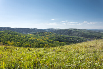 Landscape of the first days of autumn withered grass in the foreground and a panorama of mountains...