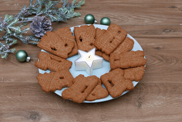 Spekulatius auf einem Teller mit Weihnachtsdeko.