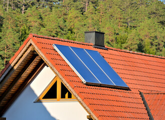 Solarthermieanlage zur Warmwassererzeugung auf rotem Hausdach