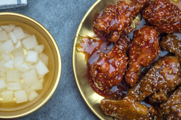 Deep fried chicken wing with garlic sauce and sweet sauce in Korean style serve with pickled radish, asian food concept.