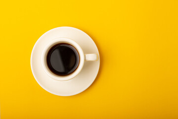 Aromatic coffee in a cup on a yellow background.Espresso. Morning drink. Cheerful morning concept. Place for text. Place to copy.
