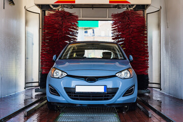 Car washing machine. Auto brush washer clean blue car on automatic carwash station. Automated car...