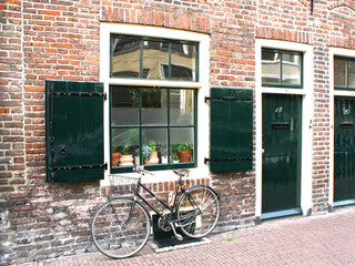 Fototapeta na wymiar Black vintage bicycle leaning on a red brick wall, Netherlands