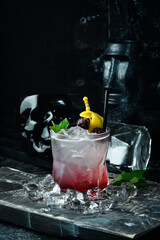 Fototapeta Cocktail with blackberry liqueur and lemon peel in a glass. Bar menu. obraz
