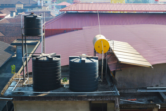 Water Tanks And Solar Panels On The Roof Of A Building In India.