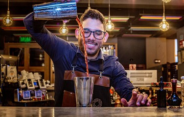 Latin Barman preparing alcoholic cocktail 